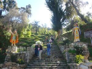 Un gruppo di persone che camminano su una rampa di scale con statue di Hostal del Sol Isla del Sol a Isla de Sol