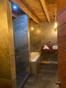 y baño con ducha, bañera y lavamanos. en Cabañas MiNa's, en Huasca de Ocampo