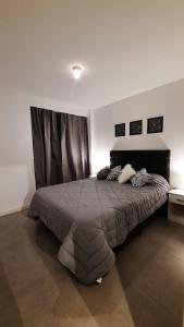 a bedroom with a large bed with a brown blanket at Dpto en Complejo Ciudad Gama in Cordoba