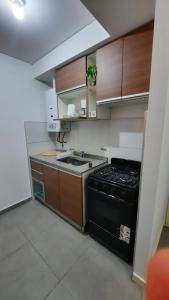 a small kitchen with a stove and a sink at Dpto en Complejo Ciudad Gama in Cordoba