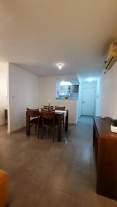 a living room with a table and chairs and a kitchen at Dpto en Complejo Ciudad Gama in Cordoba