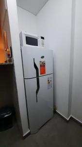 einen Kühlschrank mit einer Mikrowelle darüber in der Unterkunft Dpto en Complejo Ciudad Gama in Cordoba