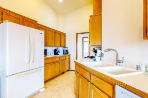 a kitchen with a white refrigerator and wooden cabinets at La Cana Street Leisure - Main Home & In-Law suite in Coupeville +40 photos