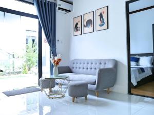 een woonkamer met een bank, een bed en een tafel bij QV Luxury Apartment in Phan Rang