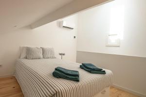 a bedroom with a bed with two green towels on it at New Bluebell house in heart of Porto in Porto