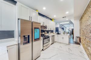 a kitchen with white cabinets and a brick wall at Brixton Manor in Baltimore