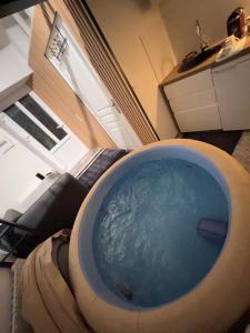- un salon avec une grande baignoire en face d'un canapé dans l'établissement Maison spa, à Soisy-sur-Seine