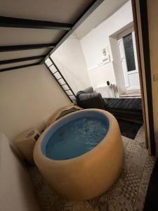 - une salle de bains avec une grande baignoire au milieu d'une pièce dans l'établissement Maison spa, à Soisy-sur-Seine