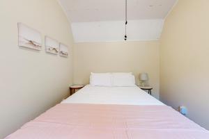 a bedroom with a large white bed with pink sheets at Addies Nest in Sevierville