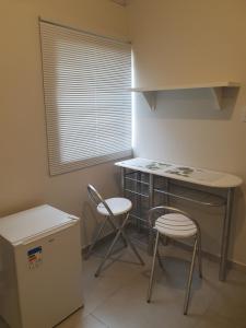 une cuisine avec deux chaises, une table et un comptoir dans l'établissement Suíte privativa confortável, à Diamantina