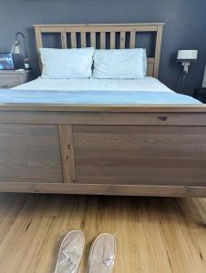 a bed with a wooden frame and shoes on the floor at Lunar Escape in Glenbrook