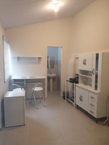 a kitchen with a counter and a table and chairs at Suíte privativa confortável in Diamantina