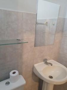 ディアマンティーナにあるSuíte privativa confortávelのバスルーム(洗面台、トイレ、鏡付)