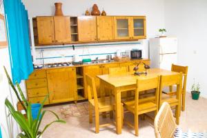 cocina con armarios de madera y mesa de madera en Relaxing Blue Flat near beach!, en Calheta Do Maio