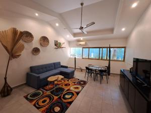 Casa Mapache في تاماريندو: غرفة معيشة مع أريكة زرقاء وطاولة