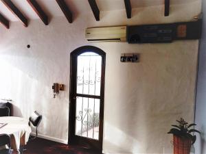 une porte dans un mur blanc avec une table et une plante dans l'établissement Departamento 1º P, 2 personas, WIFI, confortable, mucha luz natural, à Godoy Cruz