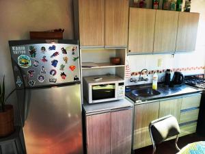 a kitchen with a stainless steel refrigerator with magnets at Departamento 1º P, 2 personas, WIFI, confortable, mucha luz natural in Godoy Cruz