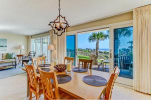 a dining room and living room with a table and chairs at Captains Court 1019 in Fernandina Beach