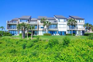 a large apartment building on a hill with palm trees at Captains Court 1019 in Fernandina Beach
