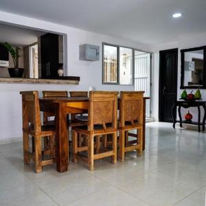 cocina con mesa de madera y sillas en Jiisot Hotel, en Camarones