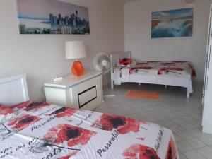 um quarto com 2 camas e uma secretária com uma cama sidx sidx em Les ptits flamboyants em Basse-Terre