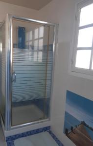 a shower in a bathroom with a window at Les ptits flamboyants in Basse-Terre