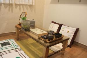 Lydia Craft Guesthouse في سول: غرفة معيشة مع طاولة وأريكة