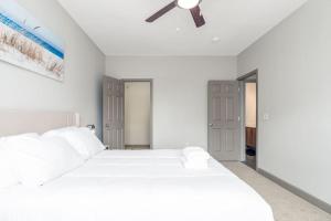 印第安纳波利斯Affordable 1BD Keystone的白色卧室配有白色的床和吊扇