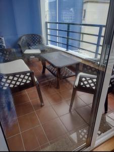 einen Tisch und Stühle auf einem Balkon mit Tisch und Stühlen in der Unterkunft Apartamento Piscina Playa Cedeira in Cedeira