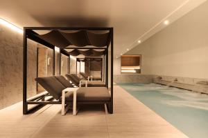 a room with a swimming pool with a massage table and chairs at Kimpton - Blythswood Square Hotel, an IHG Hotel in Glasgow
