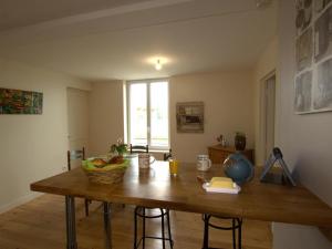 een keuken met een houten tafel met fruit erop bij Appartement Chazelles-sur-Lyon, 2 pièces, 2 personnes - FR-1-496-298 in Chazelles-sur-Lyon