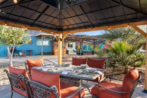 um pátio com uma mesa e cadeiras debaixo de um guarda-sol em 2 King Beds, Mountain Views! The Hummingbird House em Phoenix