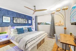 een slaapkamer met een bed met blauwe muren en een tafel bij 2 King Beds, Mountain Views! The Hummingbird House in Phoenix