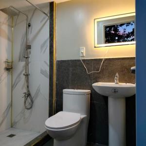 a bathroom with a toilet and a sink at Guest Homey in Iloilo City