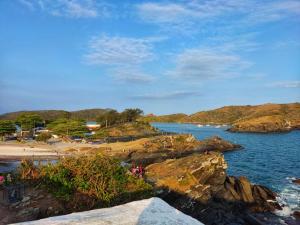 a view of a beach with people on the rocks at Condominio Chateau Mondrian in Cabo Frio