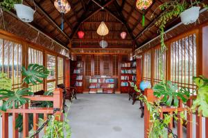 uma biblioteca com mesas, cadeiras e livros em ZEN RETREAT HOI AN em Hoi An