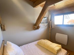 um quarto com uma cama com uma almofada amarela em Appartement Montgenèvre, 4 pièces, 8 personnes - FR-1-445-192 em Montgenèvre