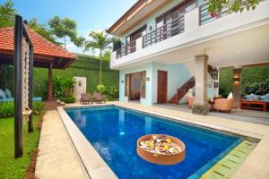 eine Villa mit einem Pool und einem Haus in der Unterkunft Kecapi Villa Seminyak by Ini Vie Hospitality in Seminyak