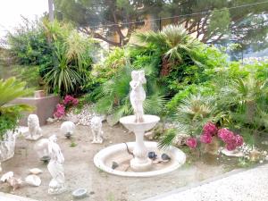 einen Garten mit einer Statue eines Springbrunnens und Pflanzen in der Unterkunft Last minute Garden and jacuzzi,the most gorgeus !adult only in La Spezia