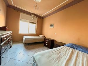 um quarto com uma cama, um lavatório e uma janela em Appartement en plein centre ville em Kenitra