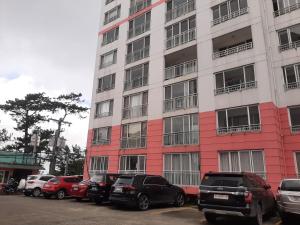 a tall building with cars parked in front of it at Minesview condo in Baguio