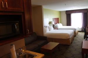 um quarto de hotel com duas camas e um sofá em Holiday Inn Express Hotel & Suites Starkville, an IHG Hotel em Starkville