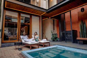 a man and woman sitting on chairs next to a swimming pool at El Recinto Luxury Hotel in San Miguel de Allende