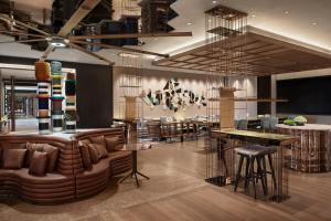 a lobby with a bar with leather chairs and tables at New World Shenyang Hotel in Shenyang