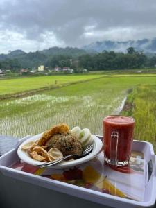 a tray with a plate of food and a drink at Purabarang Homestay in Rantepao