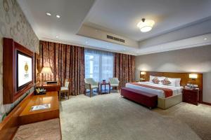 a large hotel room with a bed and a desk at Donatello Hotel in Dubai