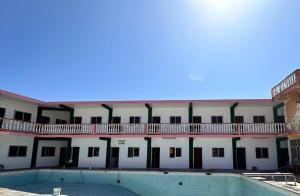 a large building with a swimming pool in front of it at Hotel Casa Cactus HCC in Chachalacas