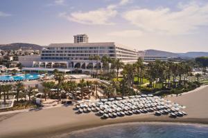 - une vue aérienne sur un complexe avec des parasols et une plage dans l'établissement Parklane, a Luxury Collection Resort & Spa, Limassol, à Limassol