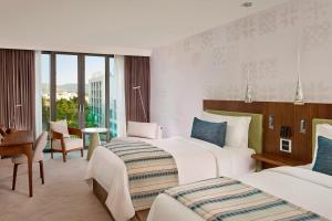 a hotel room with two beds and a desk at Parklane, a Luxury Collection Resort & Spa, Limassol in Limassol