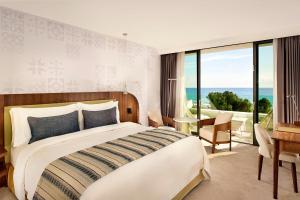 a bedroom with a large bed with a view of the ocean at Parklane, a Luxury Collection Resort & Spa, Limassol in Limassol